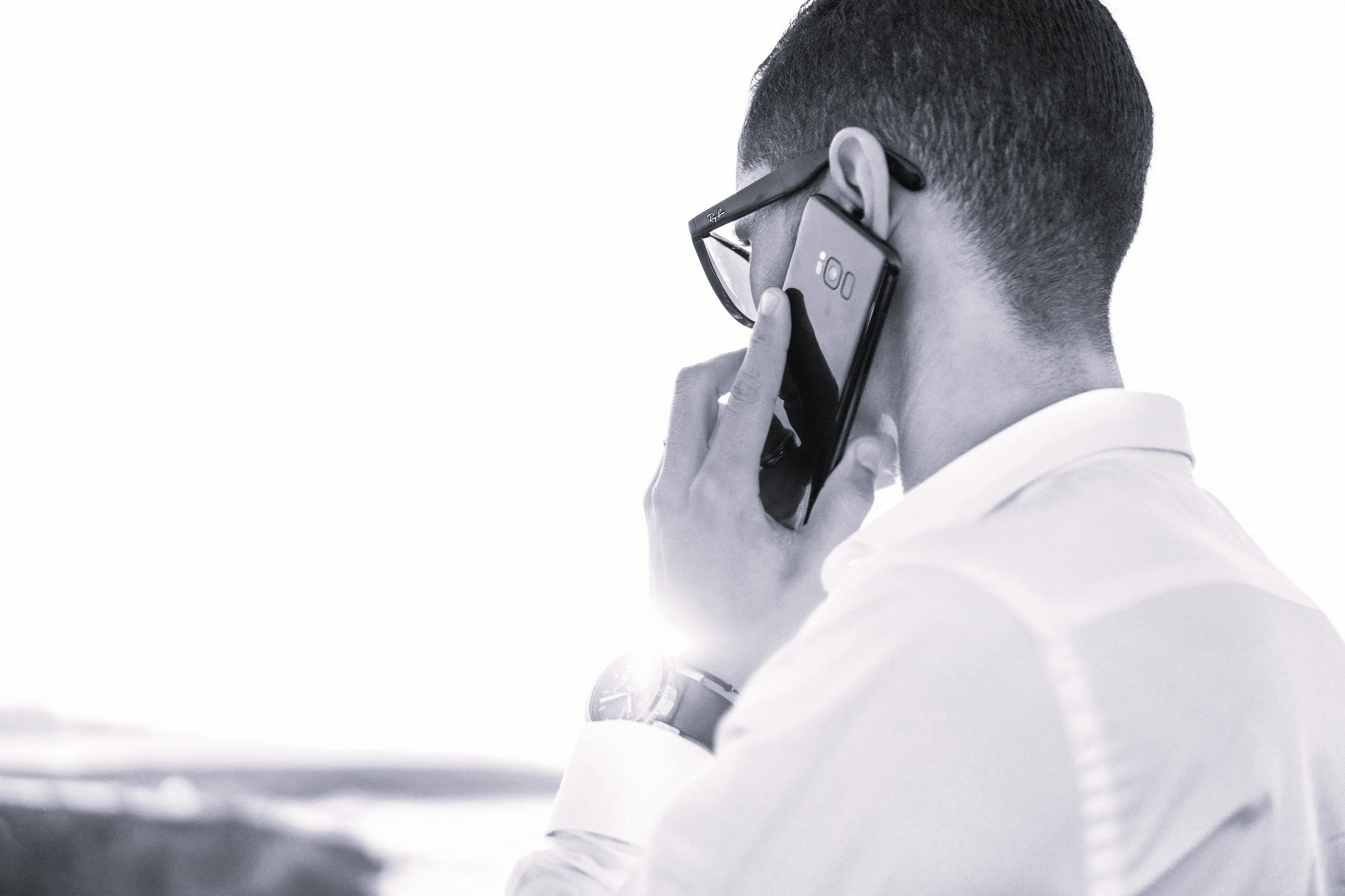 Call center agent using AI-powered dashboard to assist a customer. Black and white photo.